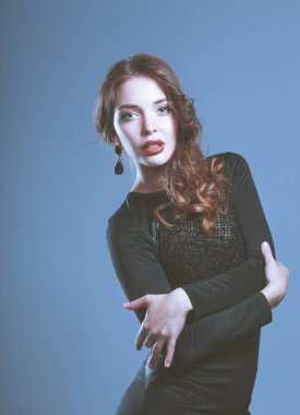 Gri arka plan üzerinde siyah elbiseli mutlu genç kadın portresi