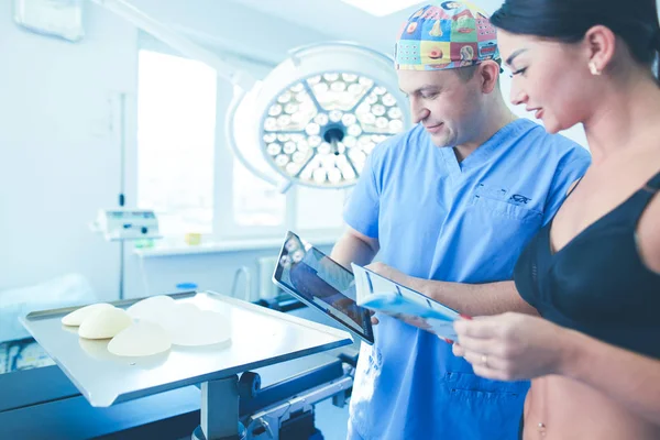 Arzt zeigt junge Patientin ihre Brust in seinem Büro im Krankenhaus — Stockfoto