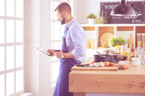 Mann folgt Rezept auf digitalem Tablet und kocht leckeres und gesundes Essen in der heimischen Küche — Stockfoto