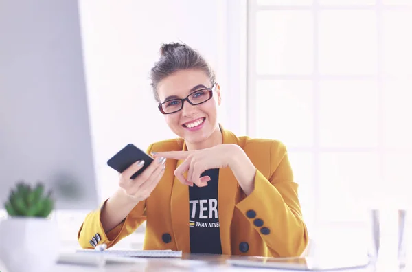 Donna d'affari seduta in ufficio con computer portatile al telefono — Foto Stock