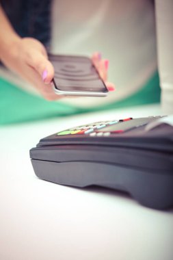 Müşteri ile smartphone Nfc teknolojisi kullanılarak dükkanda ödüyor. NFC teknolojisi. Müşteri ödeme