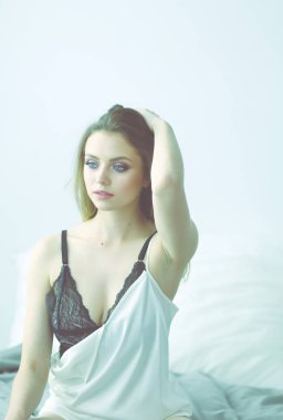 Yatakta seksi, şık bir kadın.