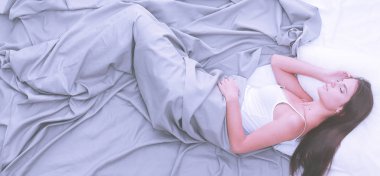 Evdeki yatakta uzanmış güzel esmer