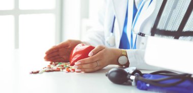 Masada kırmızı kalbi ve steteskopu olan kardiyolog.