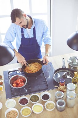 Adam ev mutfağında lezzetli ve sağlıklı yemekler hazırlıyor.