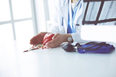 Masada kırmızı kalbi ve steteskopu olan kardiyolog.