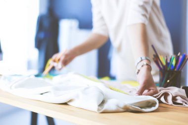 Moda tasarımcısı kadın stüdyoda tasarımları üzerinde çalışıyor..