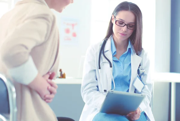 Doktorn och patienten diskuterar något när de sitter vid bordet. Medicin och hälsovård — Stockfoto