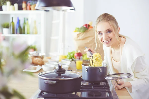 Evdeki mutfakta yemek pişiren güzel genç bir kadın. — Stok fotoğraf