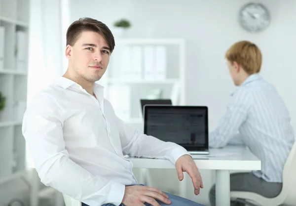 Портрет молодого человека, сидящего за столом в офисе — стоковое фото