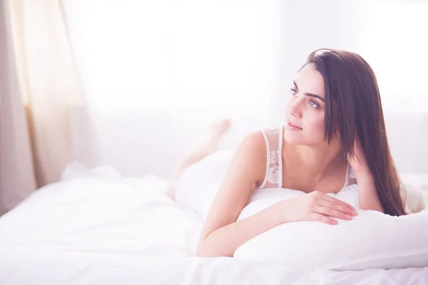 Mooie vrouw liggend op haar bed thuis — Stockfoto