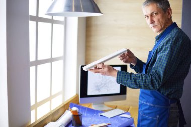 Ofisteki çizim masasında çalışan mimar