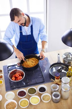 Adam ev mutfağında lezzetli ve sağlıklı yemekler hazırlıyor.