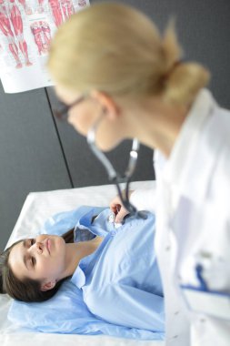 Doktor ve hasta masada otururken bir şey tartışıyorlar. İlaç ve sağlık hizmetleri kavramı
