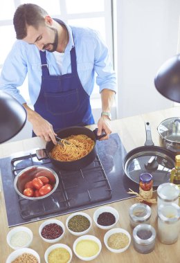 Adam ev mutfağında lezzetli ve sağlıklı yemekler hazırlıyor.