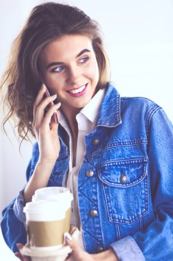 Genç iş kadını kafede telefonla konuşuyor.