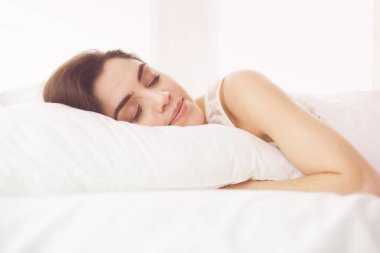 Güzel bir kadın yatağında uzanıyor.
