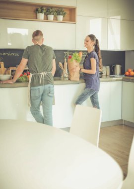 Güzel genç çift evde mutfakta eğleniyor.