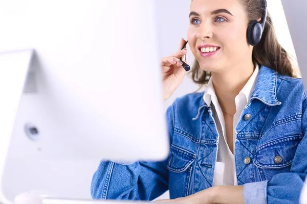 Porträtt av vacker affärskvinna som arbetar vid sitt skrivbord med headset och laptop — Stockfoto