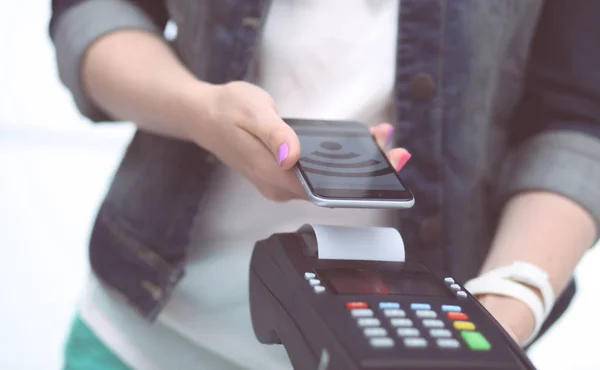 El cliente está pagando con el teléfono inteligente en la tienda utilizando la tecnología NFC. Tecnología NFC. Cliente está pagando . —  Fotos de Stock