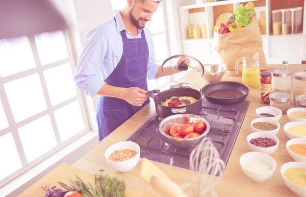 Adam ev mutfağında lezzetli ve sağlıklı yemekler hazırlıyor. — Stok fotoğraf