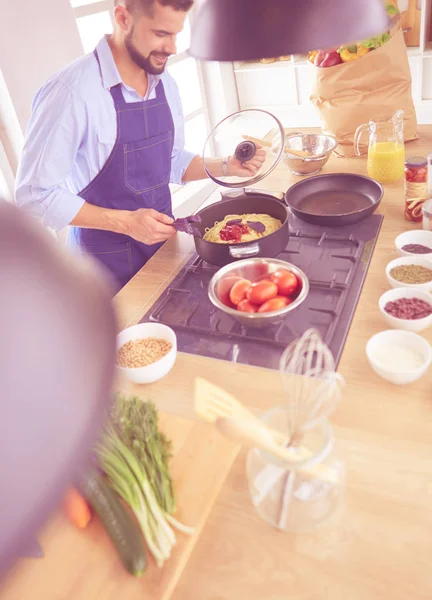 Adam ev mutfağında lezzetli ve sağlıklı yemekler hazırlıyor. — Stok fotoğraf