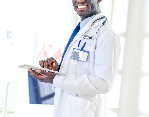 Male black doctor worker with tablet computer standing in hospital