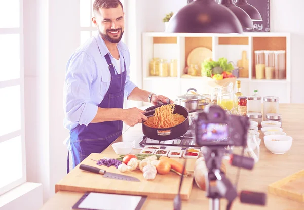 Uomo in possesso di sacchetto di carta pieno di generi alimentari sullo sfondo della cucina. Shopping e cibo sano concetto — Foto Stock