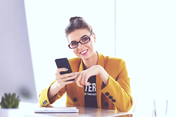 Donna d'affari seduta in ufficio con computer portatile al telefono — Foto Stock