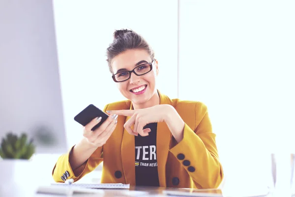 Donna d'affari seduta in ufficio con computer portatile al telefono — Foto Stock