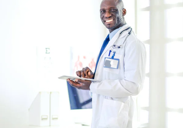 Male black doctor worker with tablet computer standing in hospital