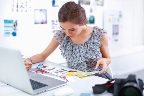 Woman reporter in office looking at photo camera — Stock Photo, Image