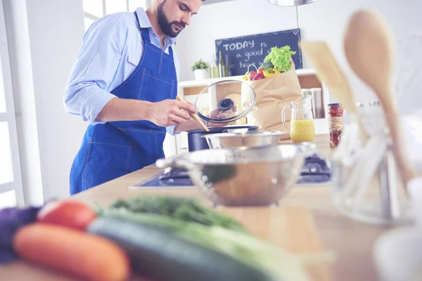 Uomo che prepara cibo delizioso e sano nella cucina di casa — Foto Stock