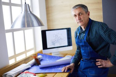 Ofisteki çizim masasında çalışan mimar