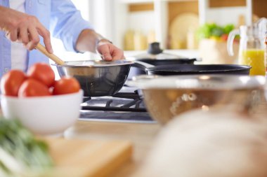 Adam ev mutfağında lezzetli ve sağlıklı yemekler hazırlıyor.