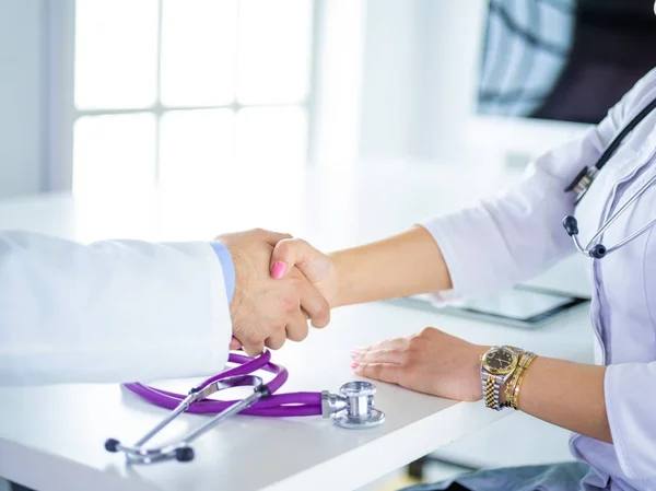 Young medical people handshaking at office