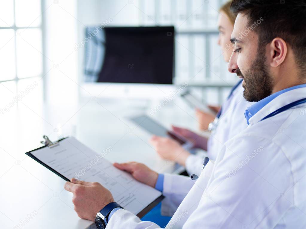 Doctors at the meeting, sitting on the desk