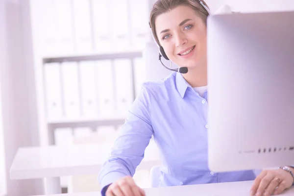 Mujer bastante joven y seria que trabaja como operador de telefonía de apoyo con auriculares en la oficina — Foto de Stock