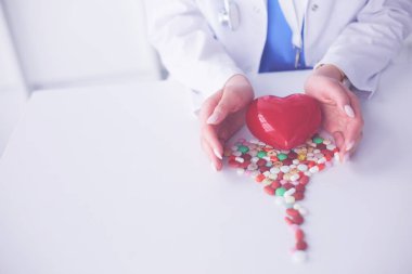 Masada kırmızı kalbi ve steteskopu olan kardiyolog.