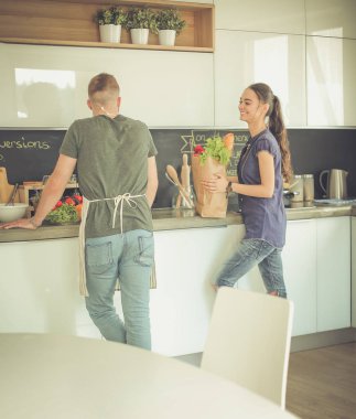 Güzel genç çift evde mutfakta eğleniyor.