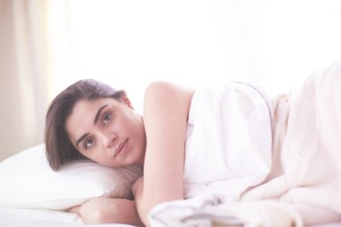 Güzel bir kadın yatağında uzanıyor.