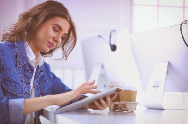 Ofiste dijital tablet kullanan genç bir kadın