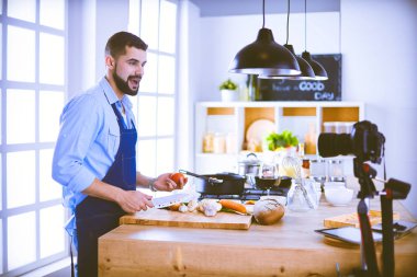 Mutfak arka planında poşet dolusu erzak tutan adam. Alışveriş ve sağlıklı gıda konsepti