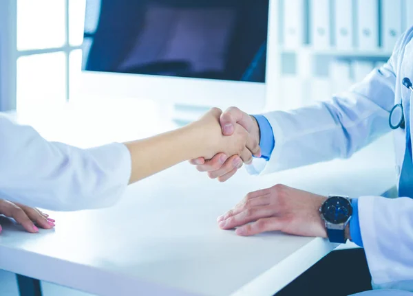 Dokter schudt handen aan patiënt in het kantoor aan de balie — Stockfoto