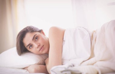 Güzel bir kadın yatağında uzanıyor.