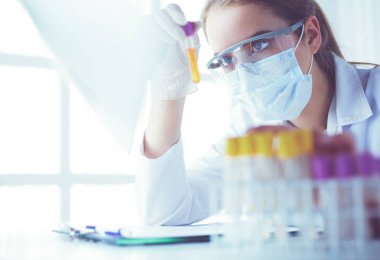Modern laboratuvar veya hastanede plastik tıbbi tüplerle çalışan araştırmacı, doktor, bilim adamı veya laboratuvar asistanı.