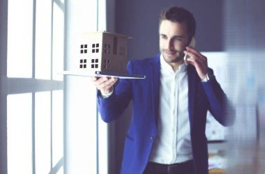 Ev minyatür Office el ayakta tutan işadamı.