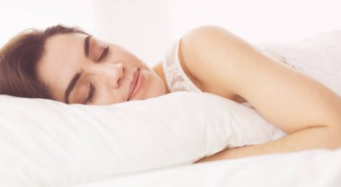 Güzel bir kadın yatağında uzanıyor.