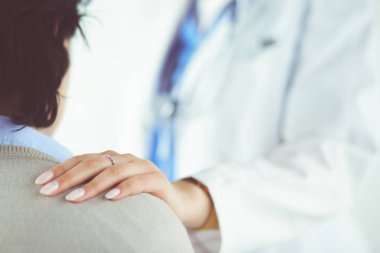 Kadın doktor bir hastaya danışmanlık yapıyor ve tıbbi bilgi ve teşhisi açıklıyor.