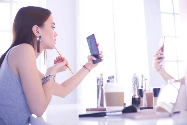 Weibliche junge schöne Mädchen mit lockigem Haar und Make-up. Schöne Frau macht Selbstporträt per Telefon — Stockfoto